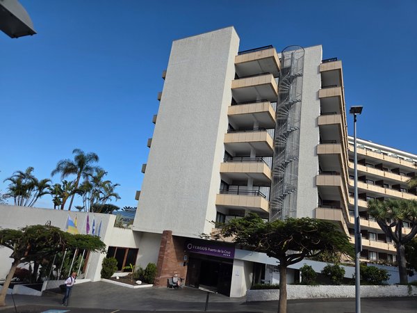Fachada del hotel Fergus Puerto de la Cruz, un edificio alto con balcones y entrada principal en la planta baja.