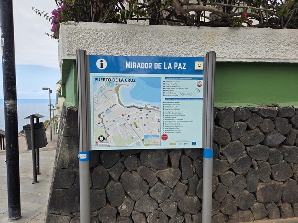 Cartel informativo del Mirador de La Paz en Puerto de la Cruz, con un mapa de la zona y puntos de interés cercanos junto al paseo marítimo.