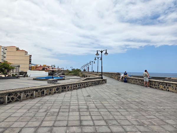 Paseo marítimo en el centro de Puerto de la Cruz con vistas al océano Atlántico y farolas alineadas.