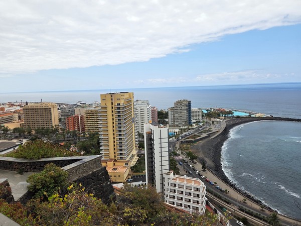 Vista panorámica del Puerto de la Cruz con sus edificios altos frente al mar y el Lago Martiánez al fondo.